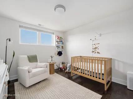 a living room with furniture and a baby crib