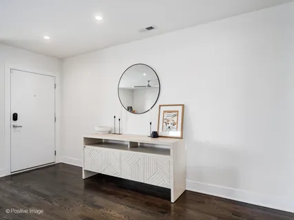 a room with wooden floor and white wooden cabinets