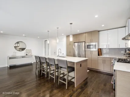 a kitchen with a dining table chairs appliances and cabinets