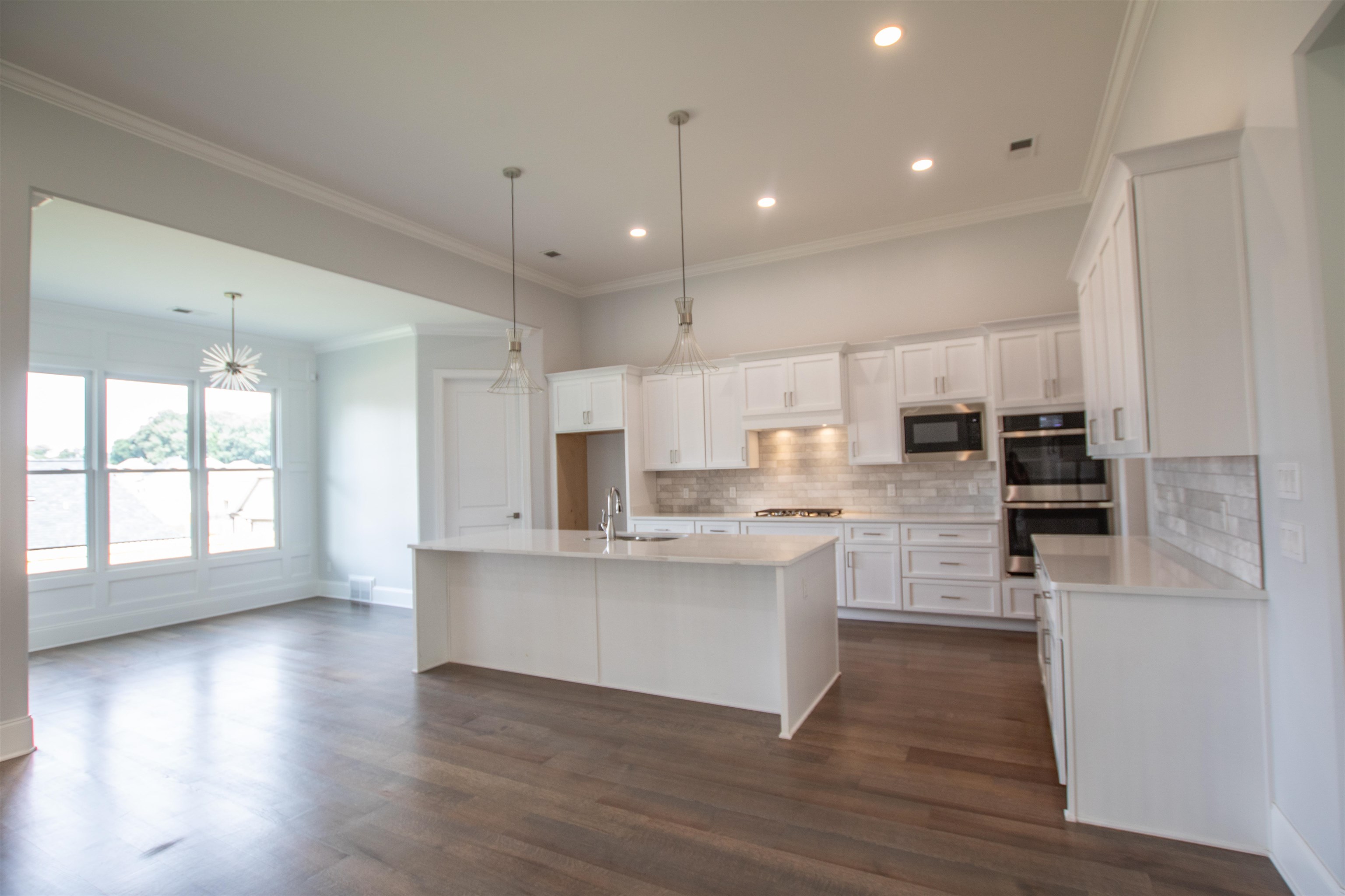 2611 Moore Road Germantown, TN 38138 - Photo 14 of 40 a kitchen with stainless steel appliances kitchen island wooden floors and white cabinets