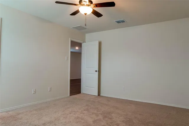 an empty room with a window and a fan