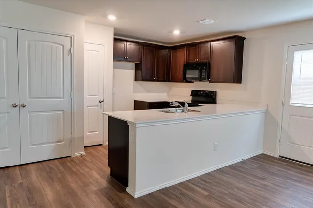 a kitchen with stainless steel appliances a refrigerator sink and microwave