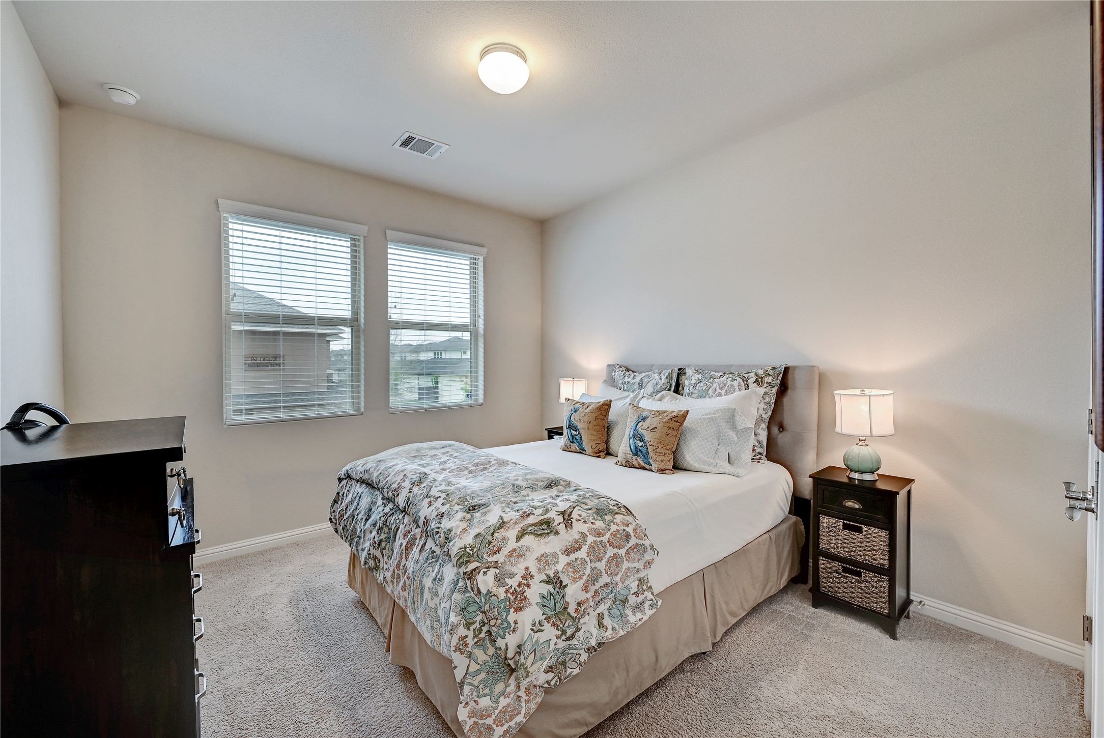 6814 East Riverside Drive, Unit 64 Austin, TX 78741 - Photo 15 of 17 Comfortable bedroom with soft carpeting and ample natural light from two windows.