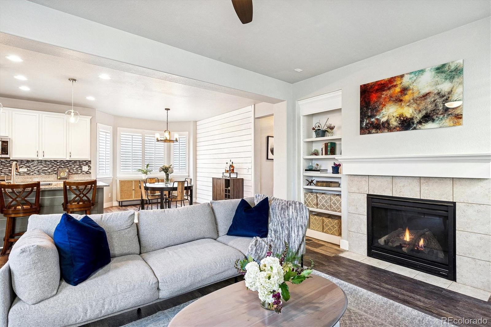 4488 Grapevine Way Castle Rock, CO 80109 - Photo 12 of 46 a living room with furniture a fireplace and a large window