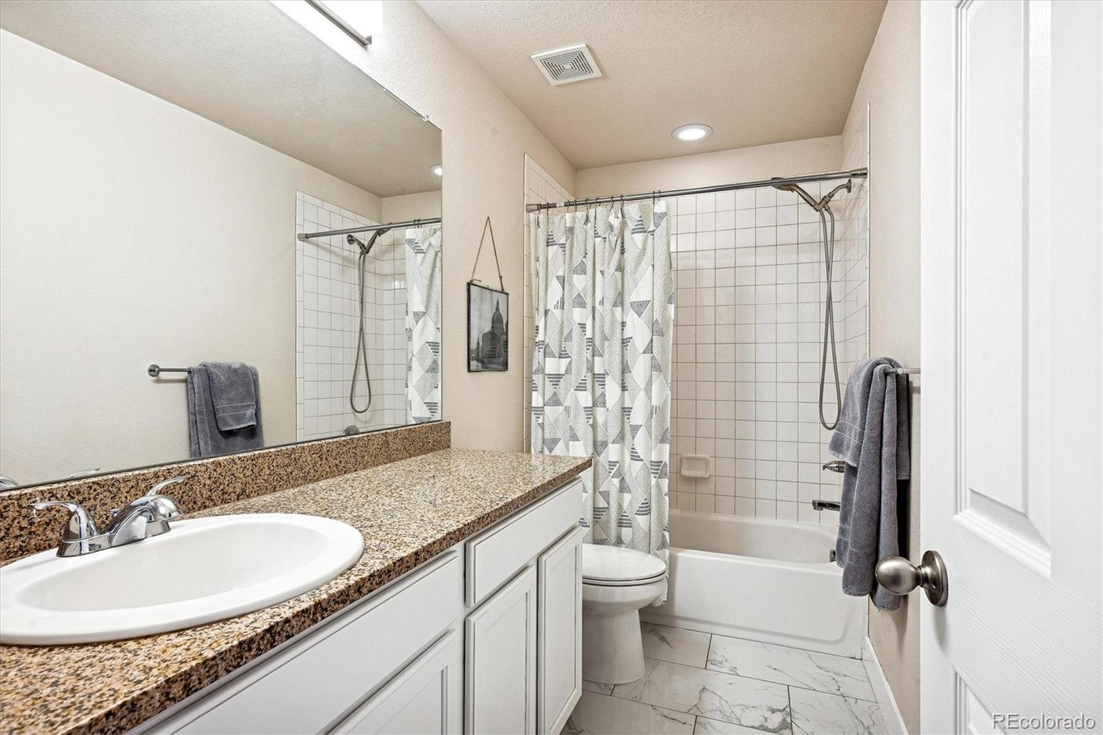 4488 Grapevine Way Castle Rock, CO 80109 - Photo 26 of 46 a bathroom with a granite countertop sink toilet and shower