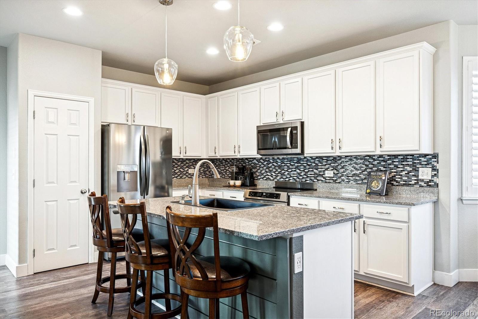 4488 Grapevine Way Castle Rock, CO 80109 - Photo 42 of 46 a kitchen with a table chairs refrigerator and microwave