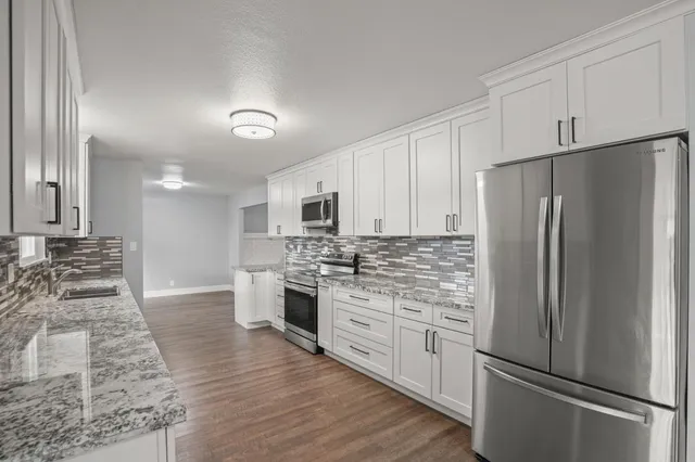 a kitchen with stainless steel appliances a refrigerator sink and stove