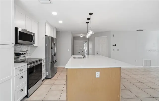 a large kitchen with kitchen island granite countertop stainless steel appliances and a sink