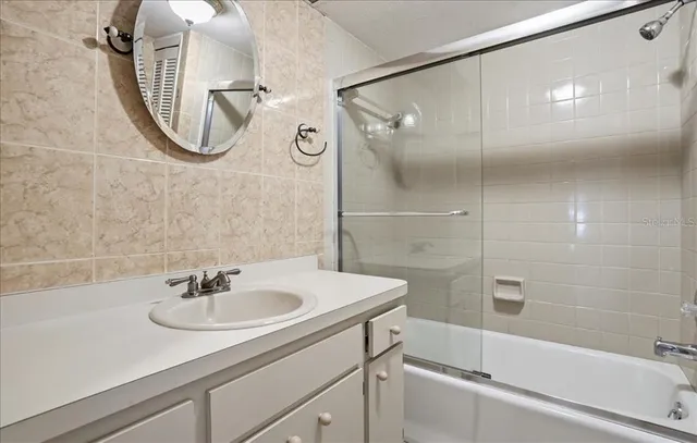 a bathroom with a sink a mirror and a shower