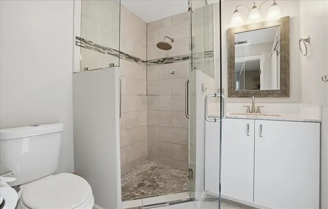 a bathroom with a granite countertop sink toilet and shower