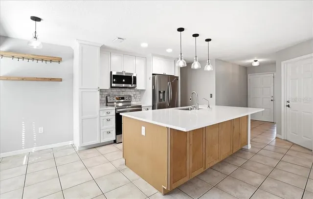 a kitchen with kitchen island a counter top space appliances and cabinets