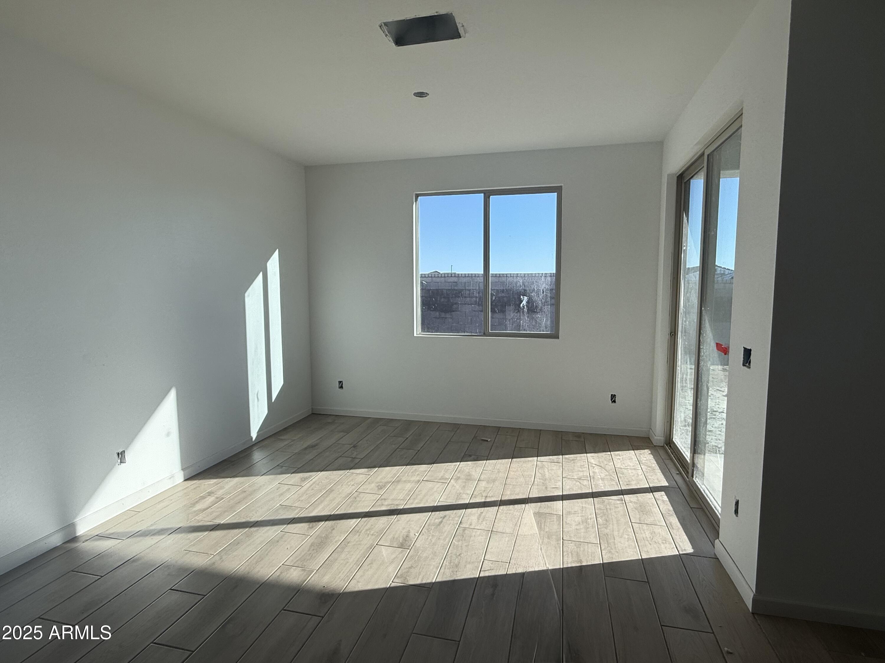 2655 Rustler Road San Tan Valley, AZ 85140 - Photo 17 of 47 a view of an empty room with wooden floor and a window