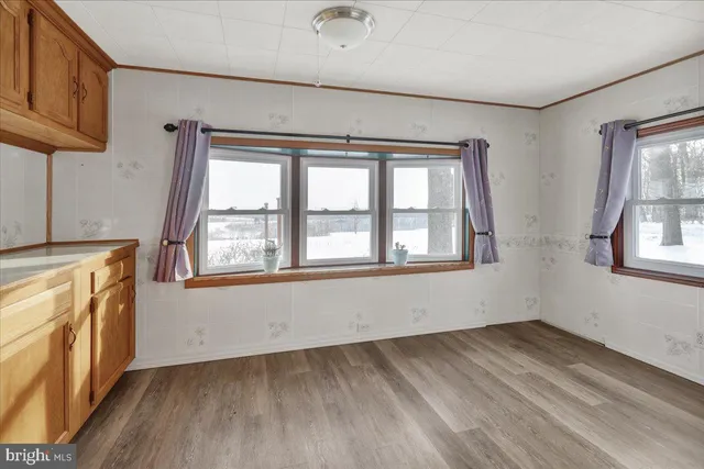 a view of a kitchen with wooden floor and a window