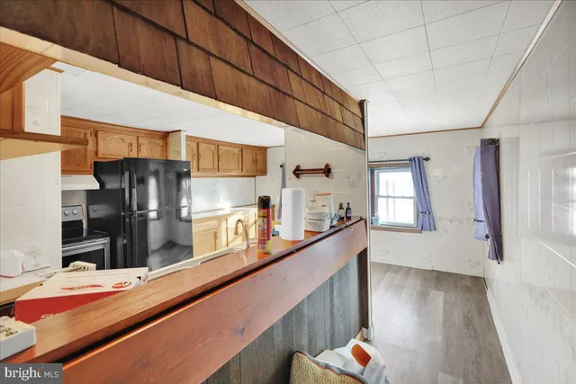 a kitchen with stainless steel appliances kitchen island granite countertop a refrigerator and a stove