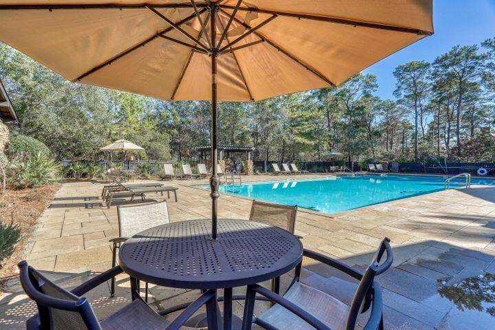 Lot 6 Cedar Post Road Santa Rosa Beach, FL 32459 - Photo 10 of 13 a patio with a table and chairs under an umbrella