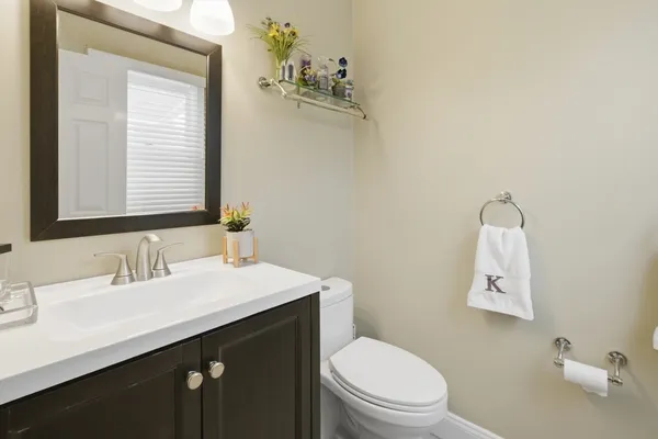 a bathroom with a sink vanity mirror and toilet