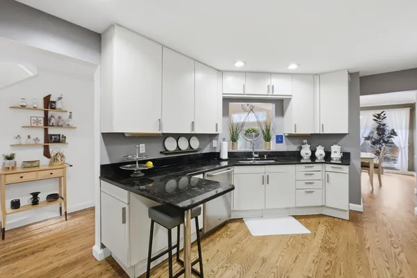 a kitchen with granite countertop a stove a sink and a refrigerator
