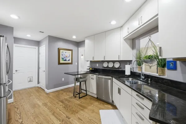 a kitchen with stainless steel appliances granite countertop a sink stove and cabinets