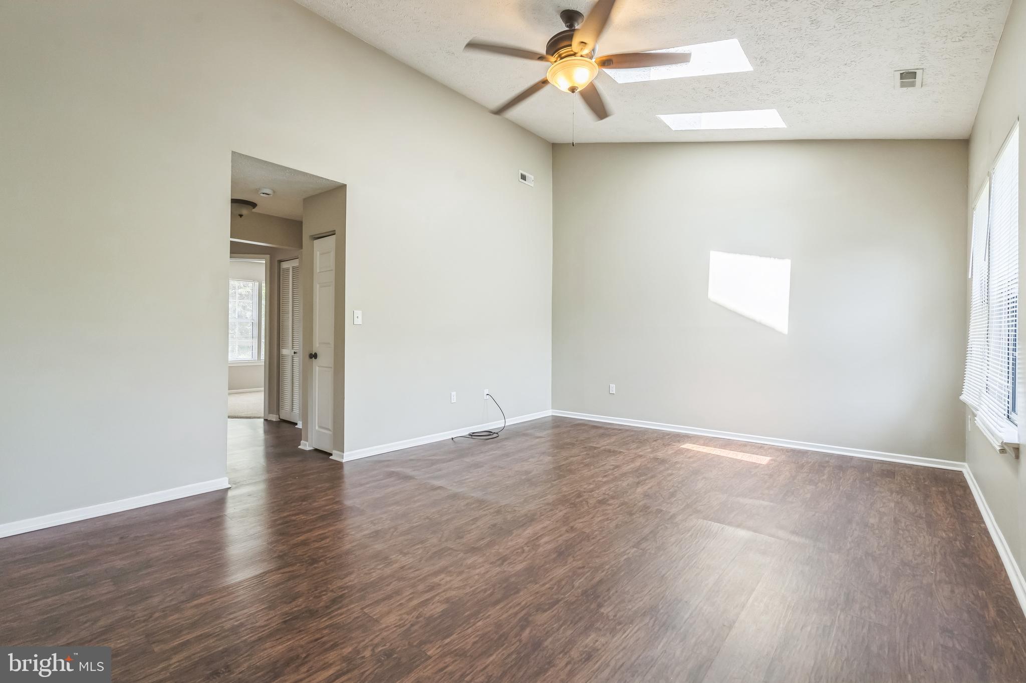 15 Beagle Run, Unit 98 Baltimore, MD 21236 - Photo 3 of 15 an empty room with wooden floor fan and windows