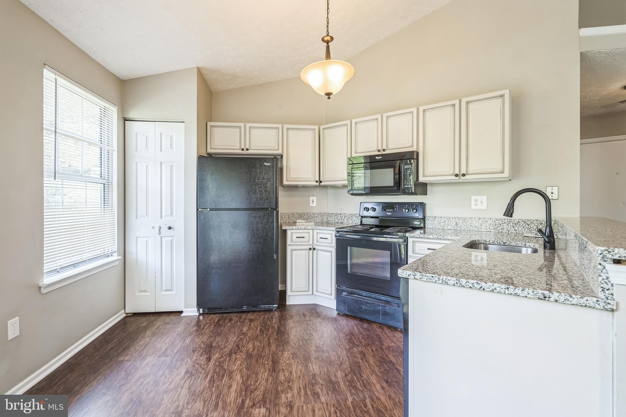 15 Beagle Run, Unit 98 Baltimore, MD 21236 - Photo 5 of 15 a kitchen with granite countertop a refrigerator stove and sink