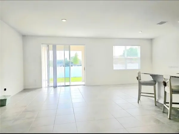 a house that is sitting in the grass with large windows