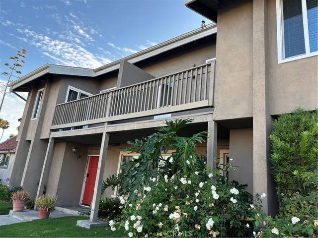 a view of a house with brick walls and flower plants