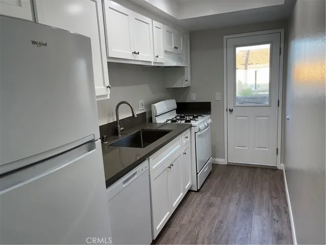 a kitchen with granite countertop a sink a stove and cabinets