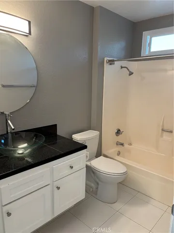 a bathroom with a granite countertop sink a toilet and bathtub