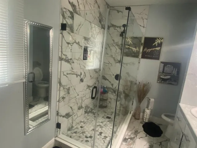 a bathroom with a shower toilet and sink