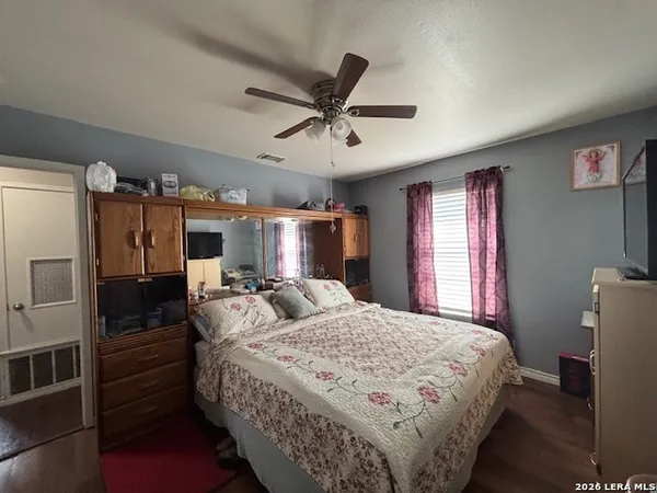 a bedroom with bed mirror and window