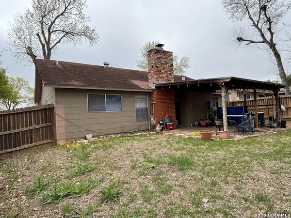 a view of a house with backyard and sitting area