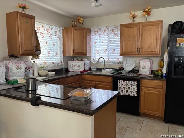a kitchen with granite countertop a sink stove and cabinets