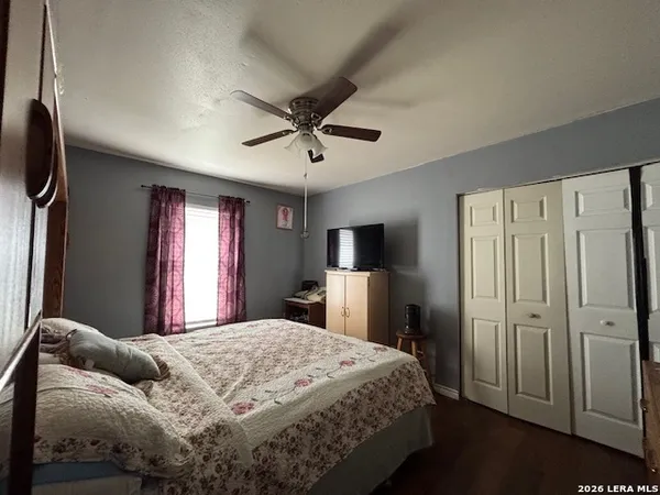 a spacious bedroom with a bed and a flat screen tv