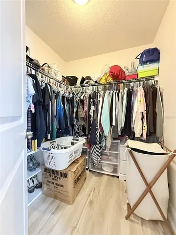 a view of walk in closet with clothes