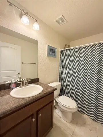 a bathroom with a sink a toilet a mirror and shower curtain