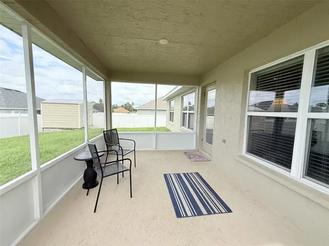a living room with hardwood floor and large windows