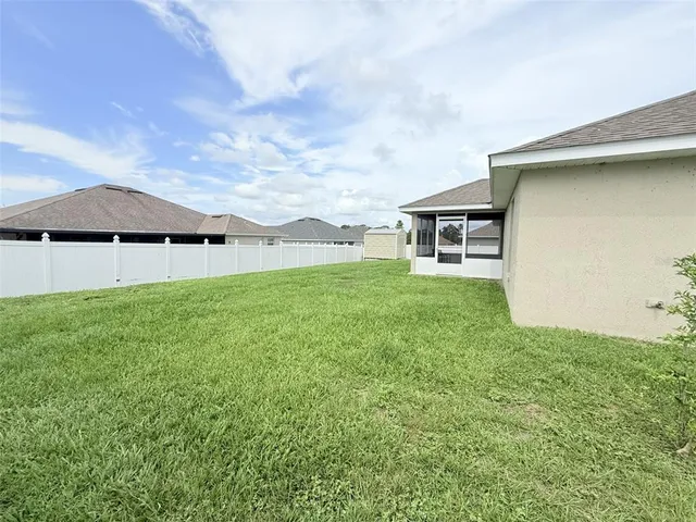a backyard of a house with table and chairs