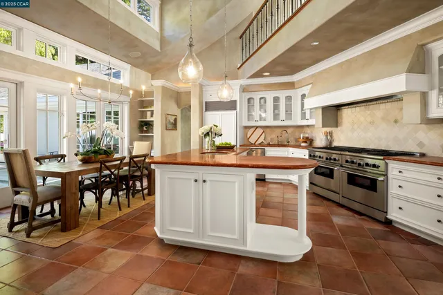 a kitchen with stainless steel appliances granite countertop a stove a sink and a dining table view