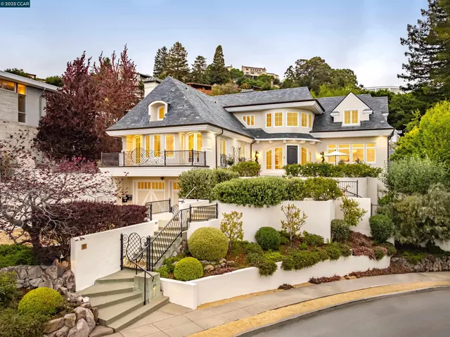 a front view of a house with a yard and potted plants