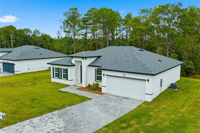a aerial view of a house next to a yard with big trees
