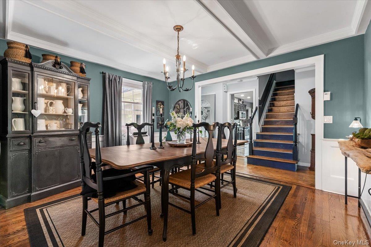 10 Rancher Place Huntington, NY 11743 - Photo 9 of 44 Dining area featuring wood-finish flooring, a coffered ceiling, and a chandelier