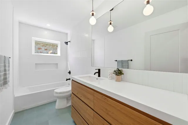 a bathroom with a bathtub a sink and a large mirror