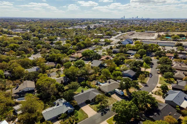 an aerial view of residential house with parking and yard