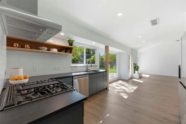 a kitchen with stainless steel appliances a stove a sink and a wooden cabinets