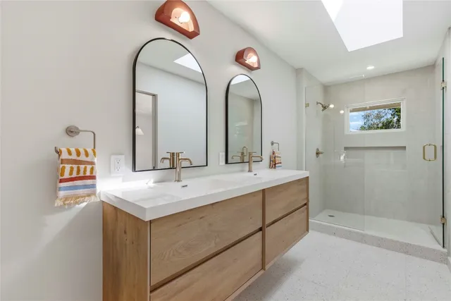 a bathroom with a double vanity sink and a mirror