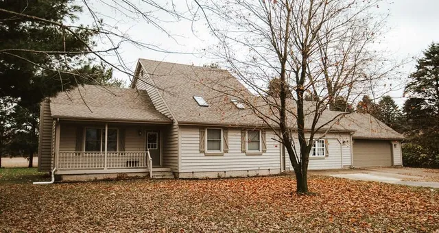 a front view of a house with a tree