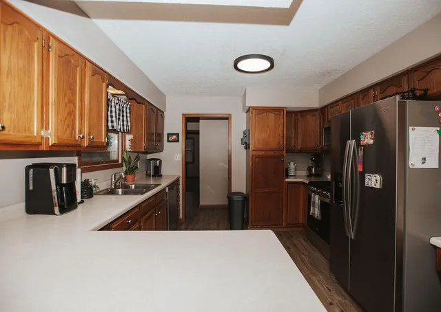 a kitchen with stainless steel appliances granite countertop a refrigerator a stove and a sink