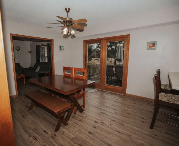 a dining room with wooden floor a chandelier