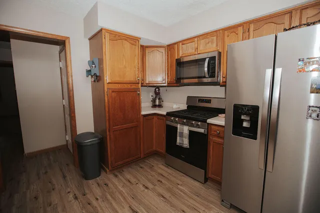 a kitchen with stainless steel appliances a refrigerator microwave and sink