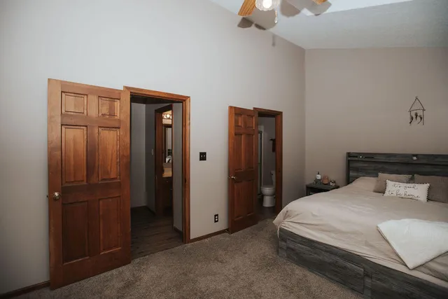 a bedroom with a bed and a chandelier fan